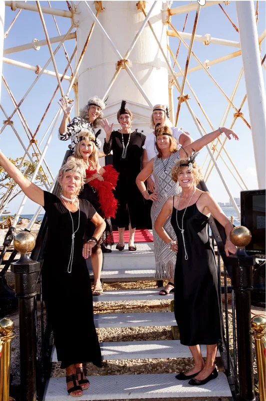 Guests in 1920s flapper dresses on the lighthouse steps